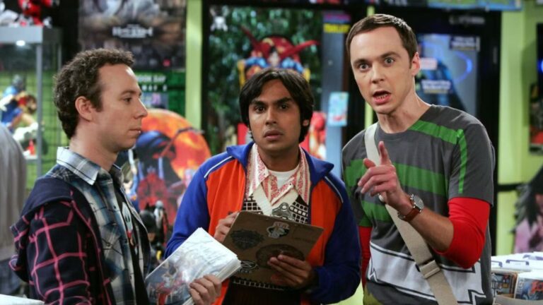 Sheldon points at something off-screen while Raj stares intently, with Stuart looking off right into space