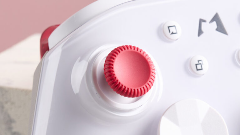 Close-up of left stick on Mobapad Huben 2, leaning on plinth with pink background