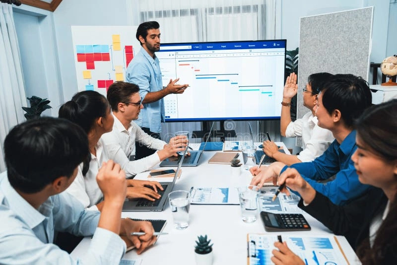 A project manager leads a team meeting using a Gantt chart to coordinate tasks and timelines, highlighting human leadership and collaboration in project management.