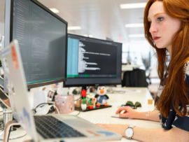 woman in green shirt sitting in front of computer